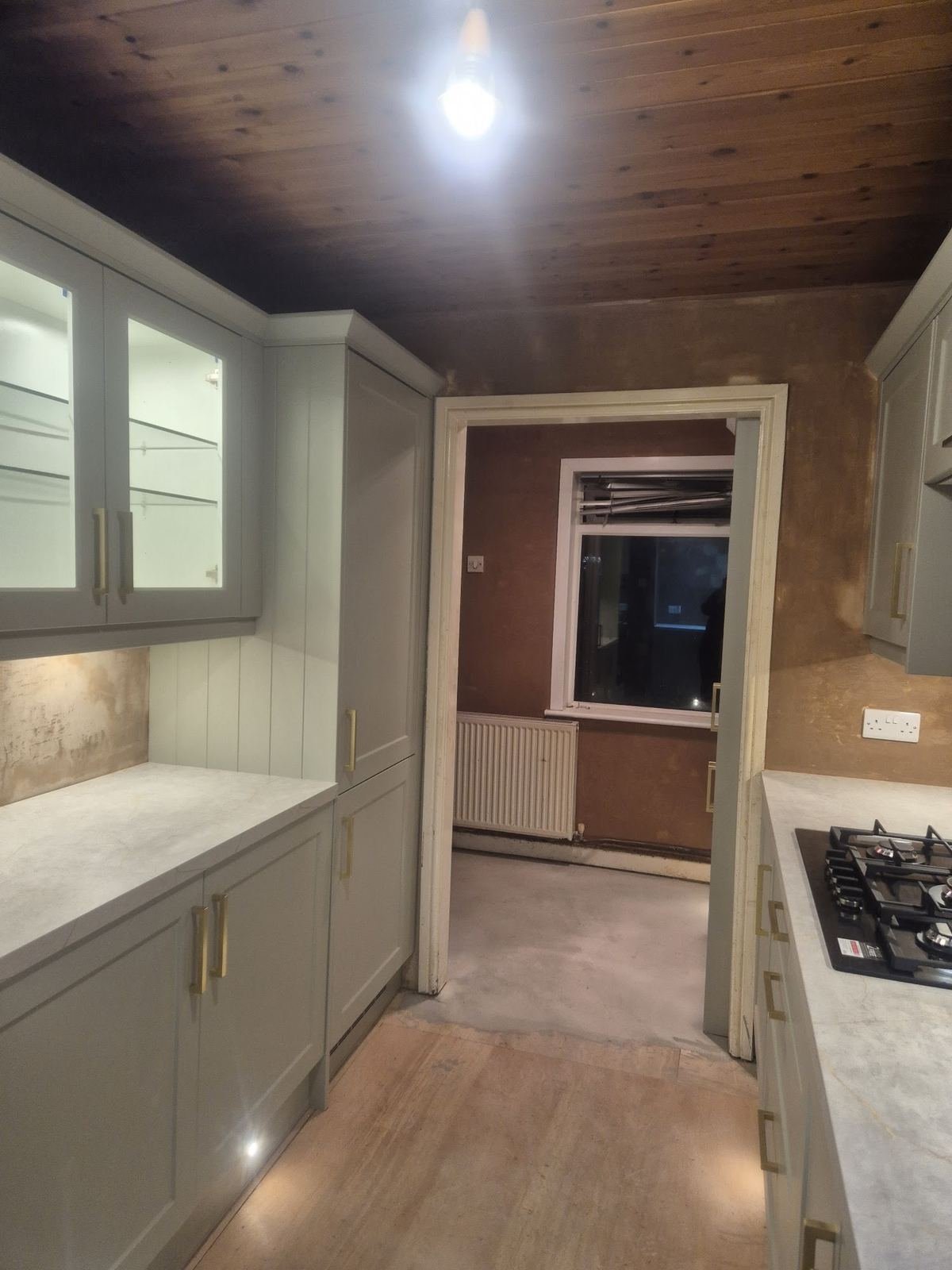 Galley kitchen with walls plastered around the new units