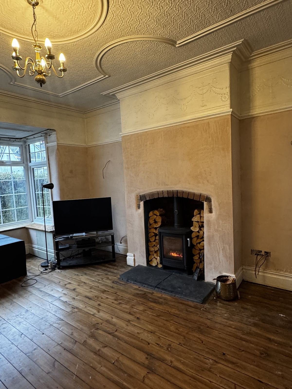 Finished living room with smooth plastered walls under an ornate ceiling